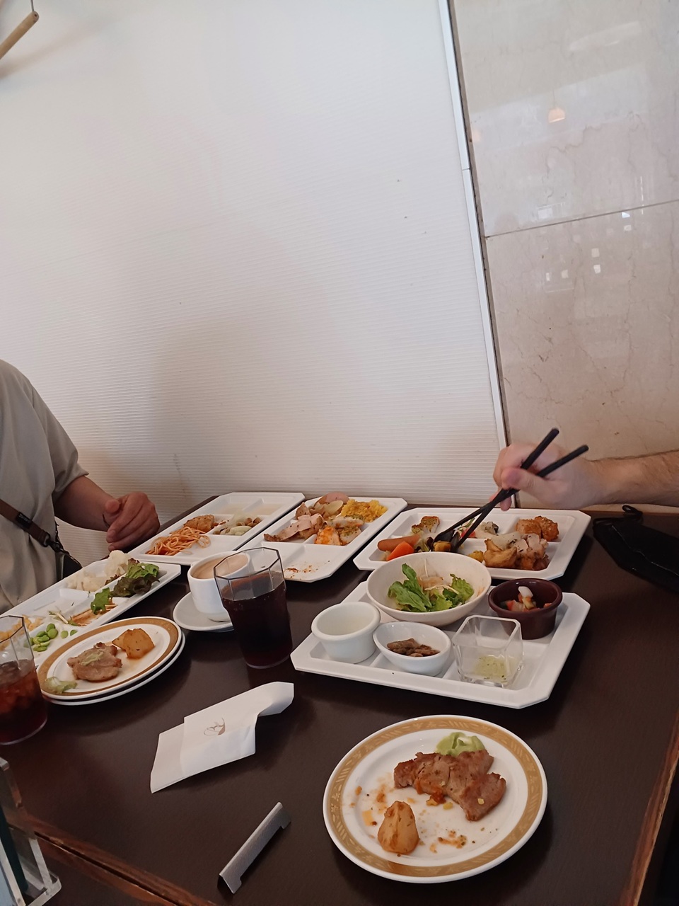 皆で楽しくポークステーキなどの料理を食べている様子
